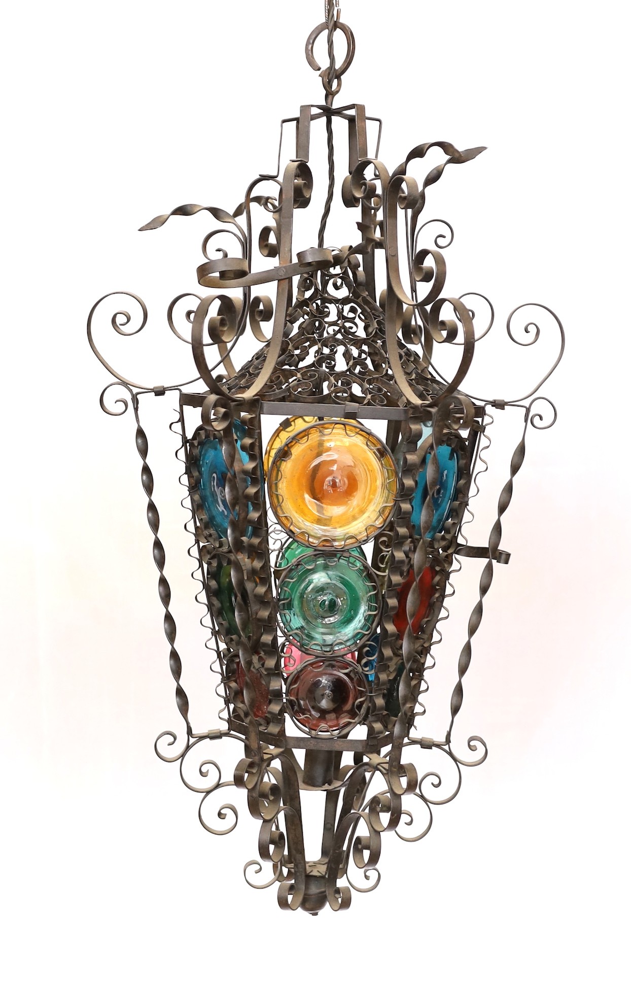 An early 20th century French wrought iron and coloured glass lantern of tapering hexagonal form, height 80cm. width 50cm